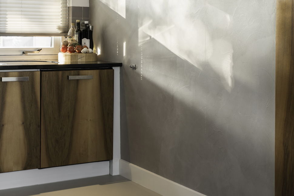Revestimiento de microcemento en pared de cocina con tonos grises